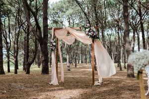Soft chiffon floral arches in woodland setting